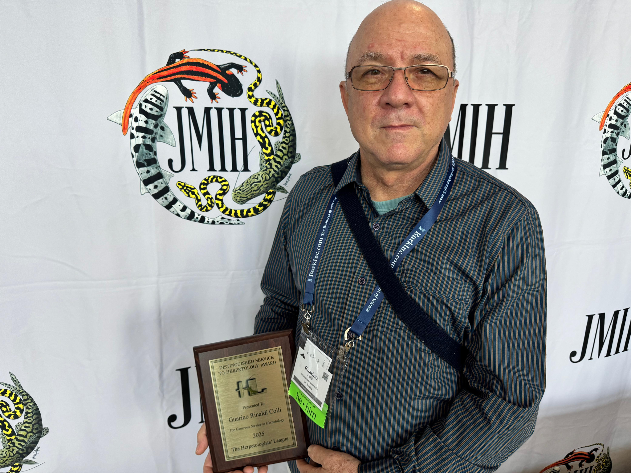 Professor Guarino Rinaldi Colli segurando sua placa de premiação.